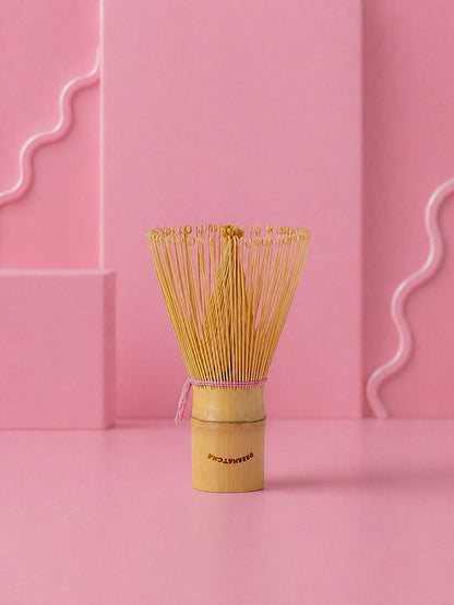 Traditional Japanese matcha whisk on a pink background with dreamatcha logo