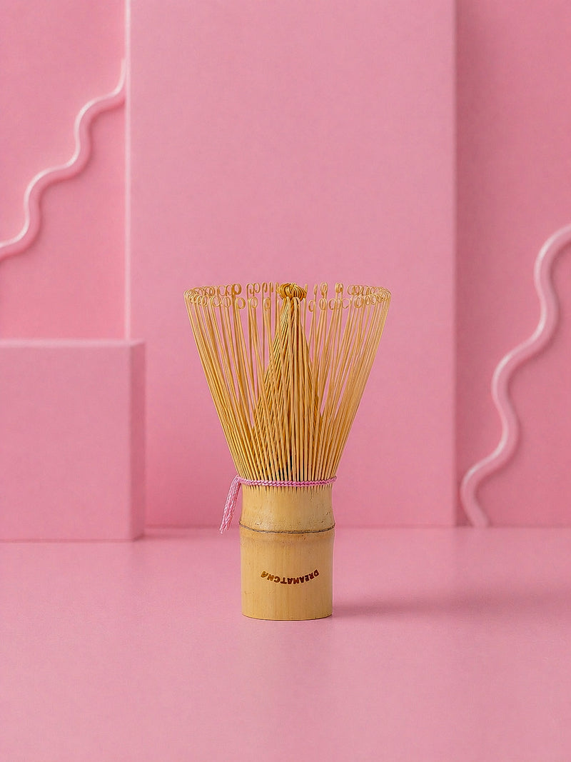 Traditional Japanese matcha whisk on a pink background with dreamatcha logo
