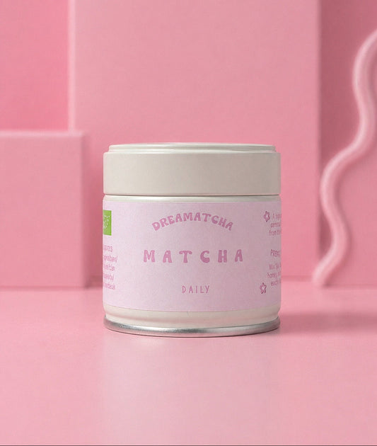 Matcha powder container with 'Dreamatcha' branding on a pink background
