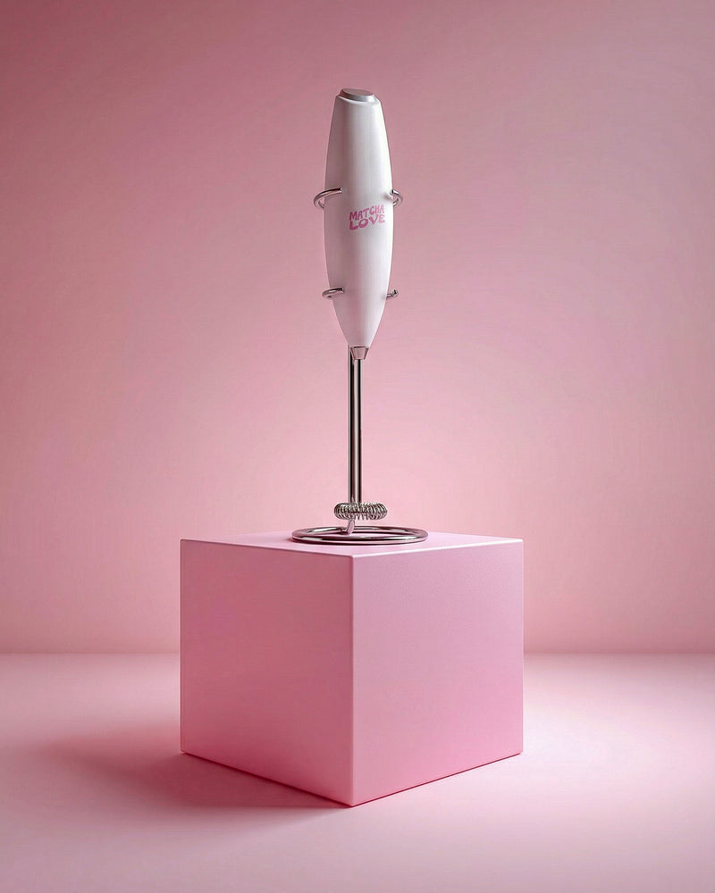 Handheld blender on a pink cube with a pink background